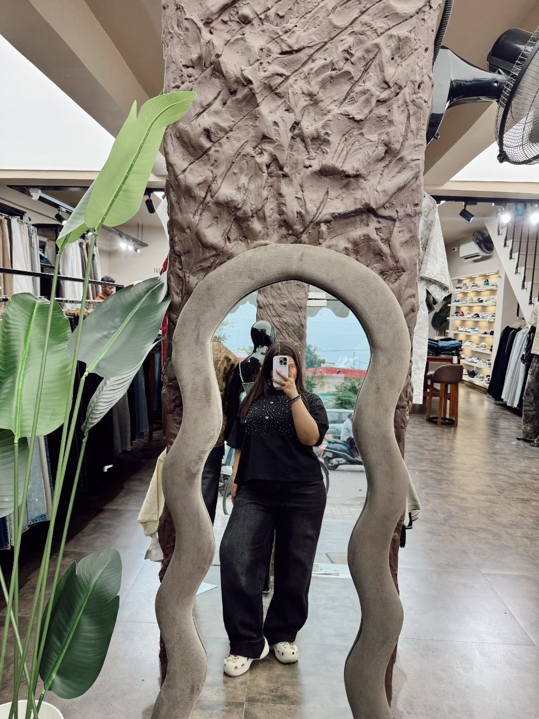 Wavy velvet mirror on a sculpted pillar inside D’ Closet